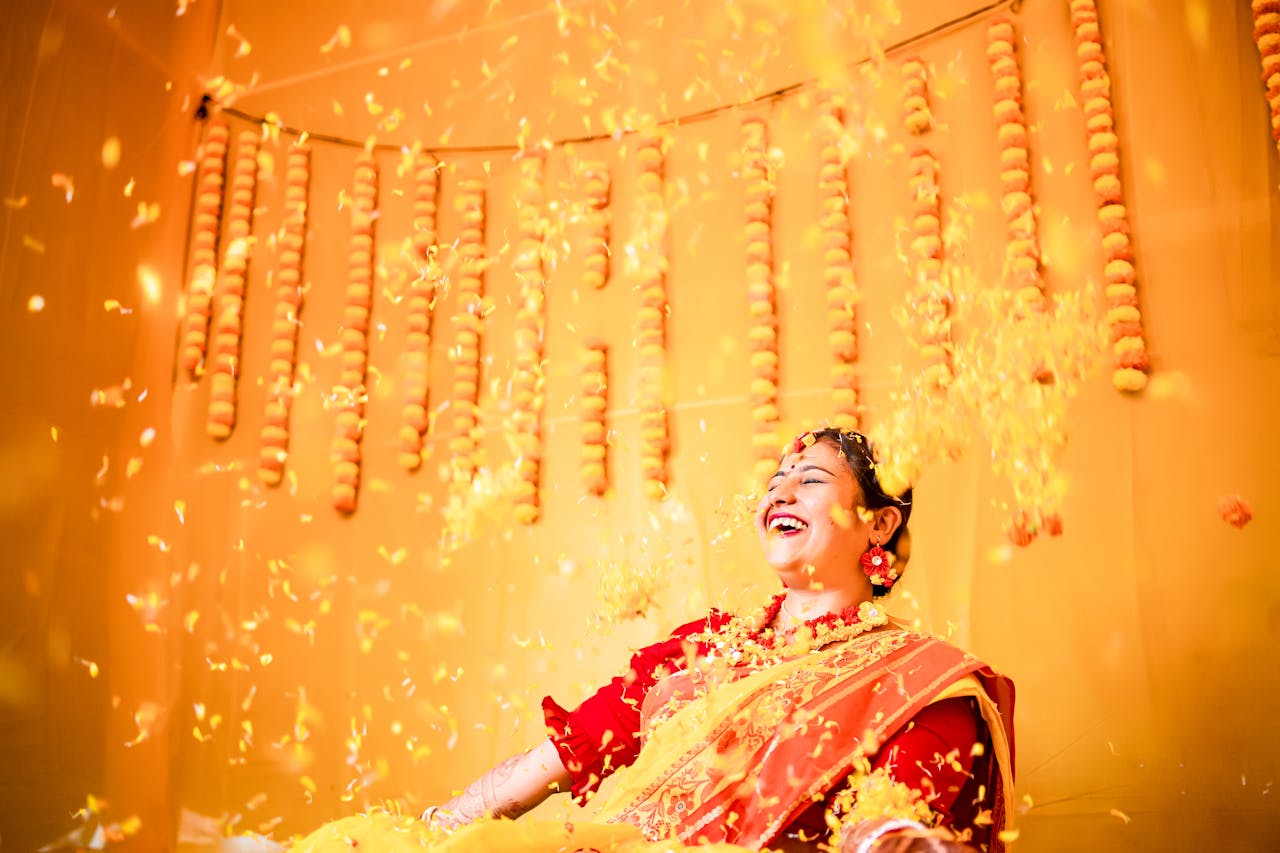 Laughing Bride in a Red Saree Among Falling Golden Petals
